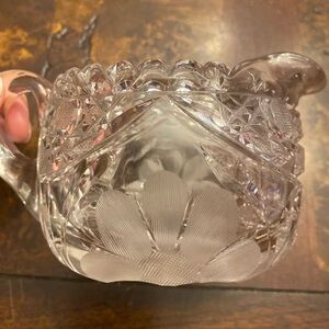 An American Brilliant Cut Glass creamer with etched floral design.